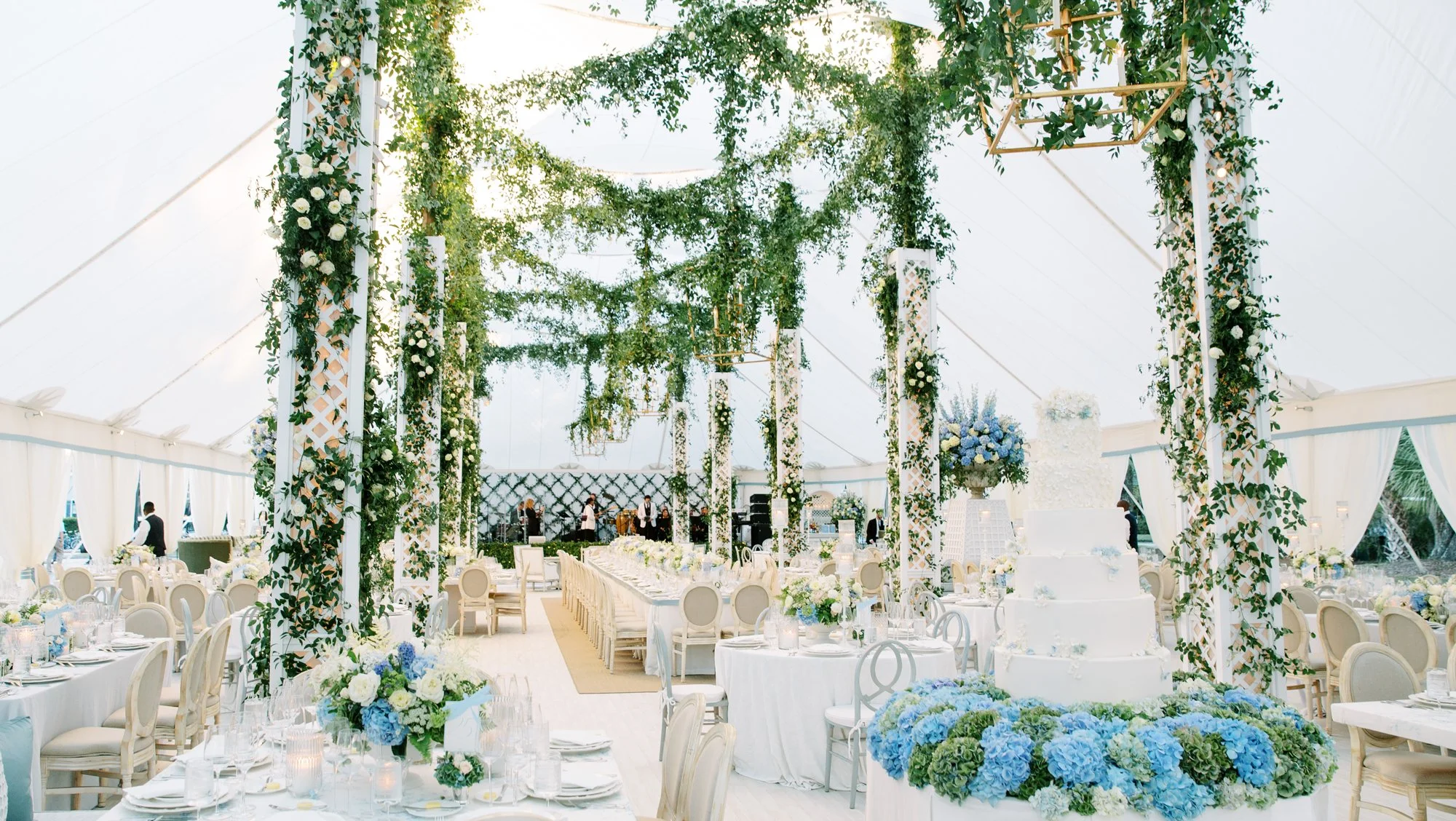 An airy reception filled with climbing greenery and white and blue flowers
